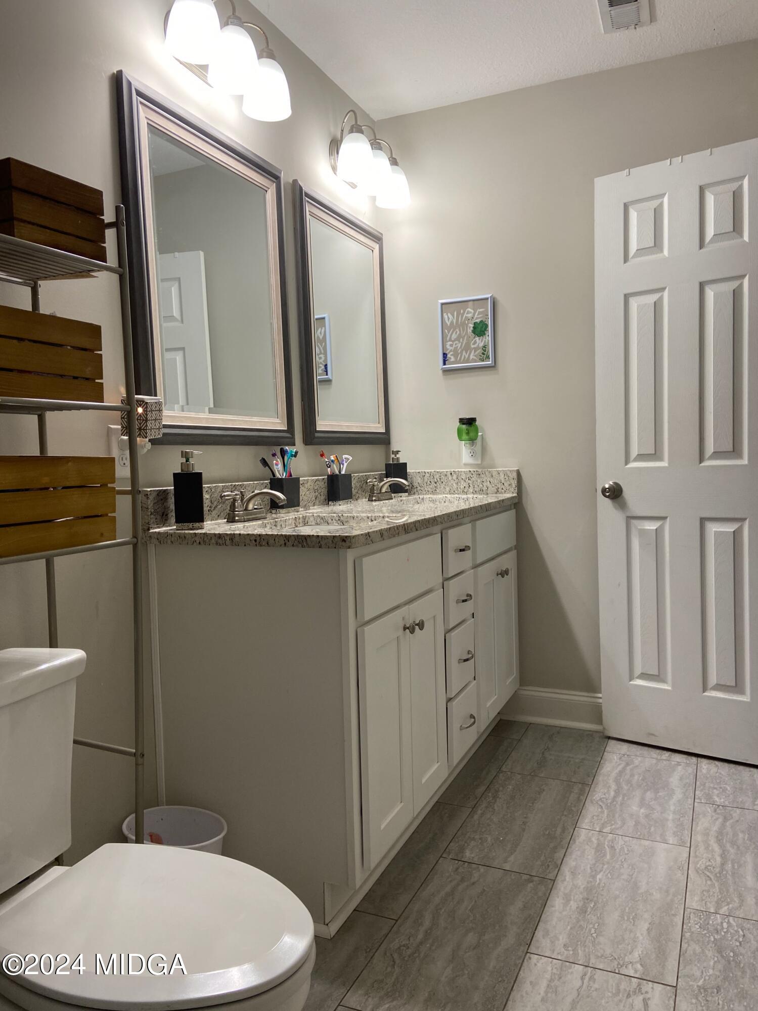 461 Schofill Road Fort Valley, GA 31030 - Photo 19 of 24 a bathroom with a double vanity sink and a mirror