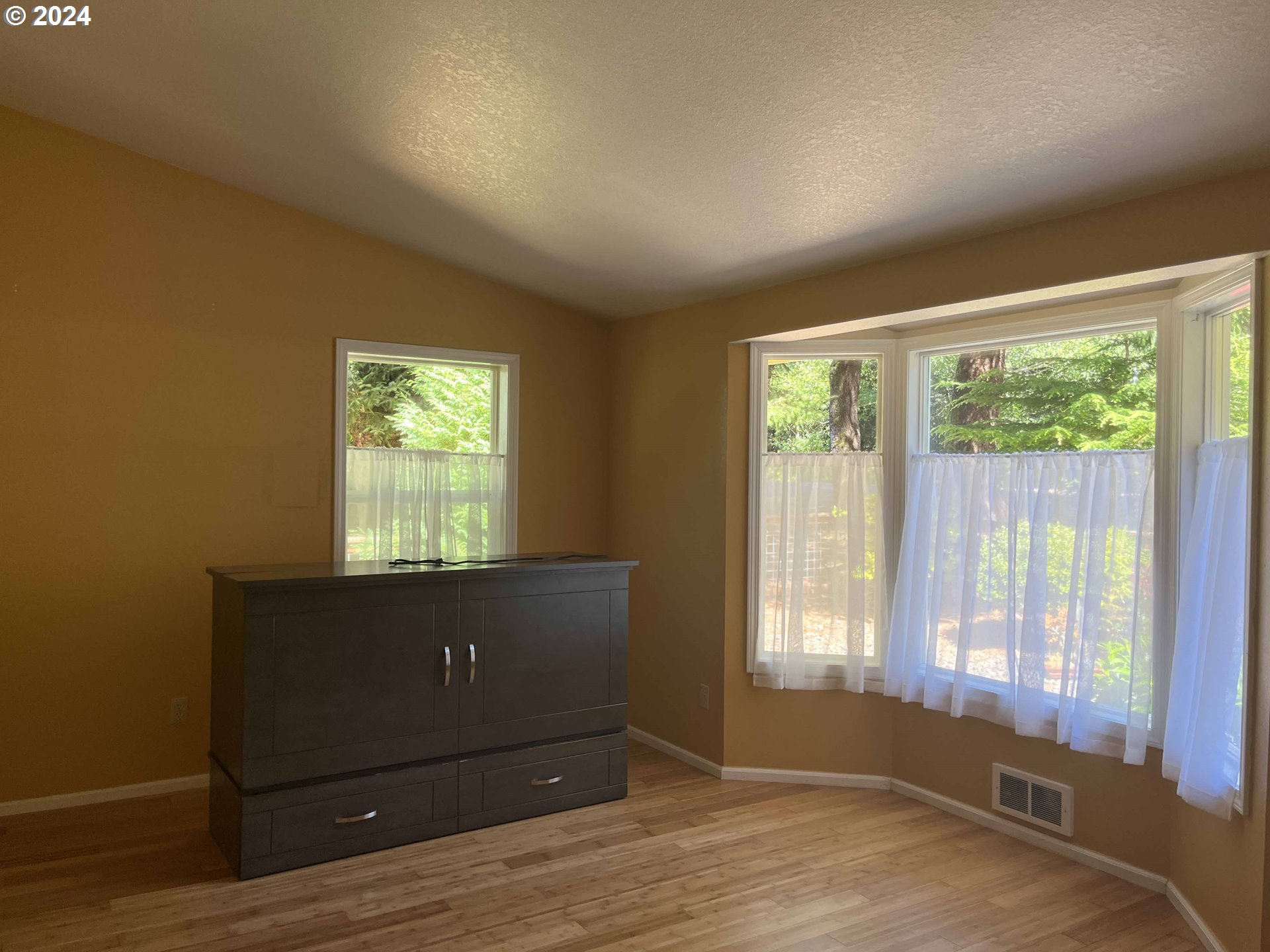 83480 Clear Lake Road Florence, OR 97439 - Photo 10 of 48 an empty room with wooden floor and windows