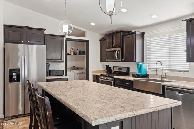 a kitchen with granite countertop a refrigerator a stove a sink dishwasher a oven with wooden cabinets and floor