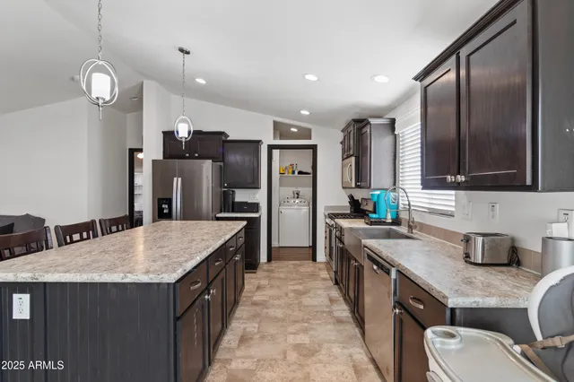 a kitchen with stainless steel appliances granite countertop a sink stove and refrigerator