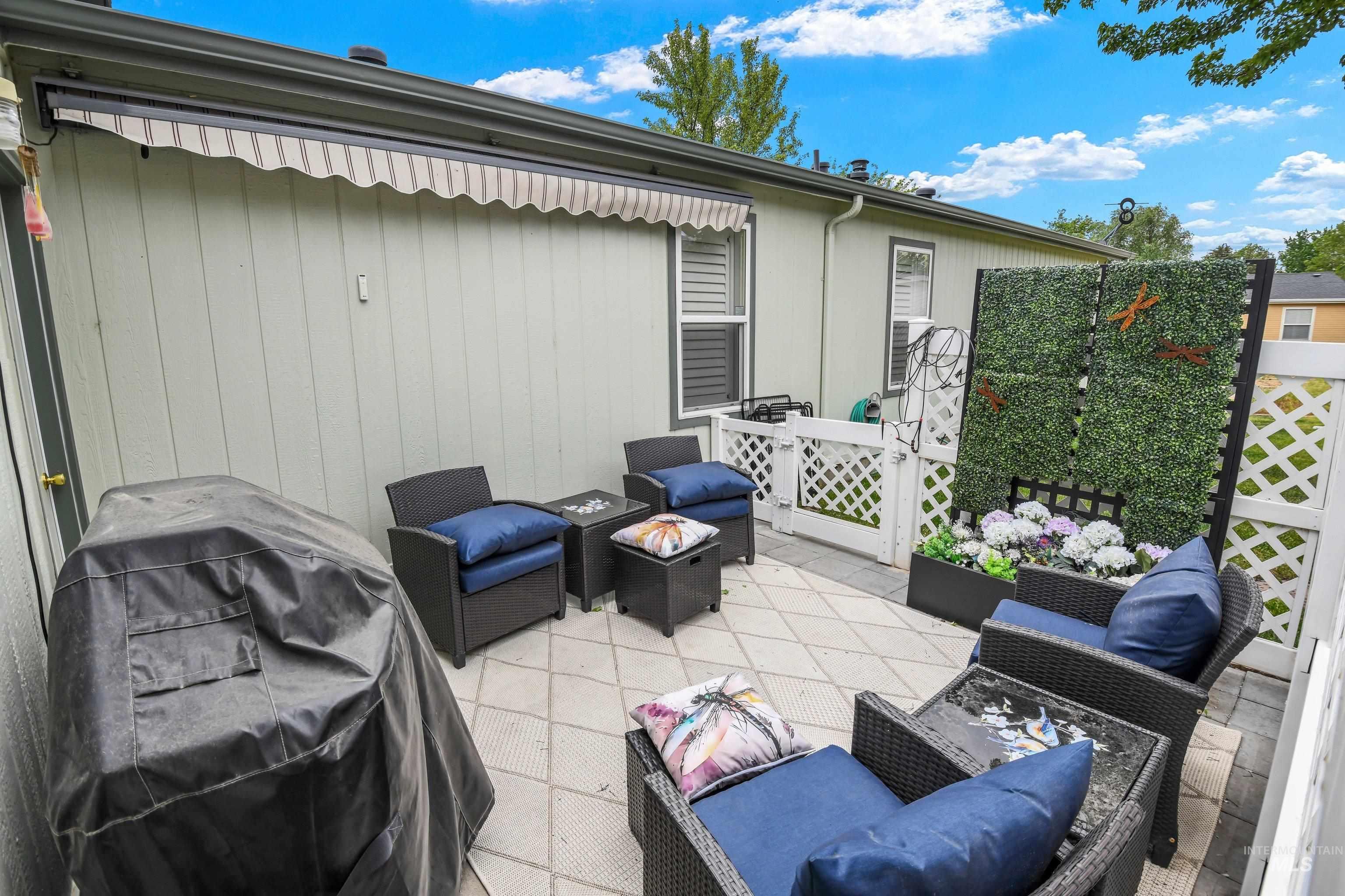 421 South Curtis Road, Unit 202 202 Boise, ID 83705 - Photo 24 of 41 Outdoor patio featuring a concrete paver surface, white lattice fencing, and an artificial greenery privacy screen with an integrated planter box