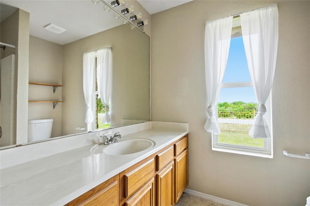 100 Pinnacle Circle Aledo, TX 76008 - Photo 22 of 30 a bathroom with a granite countertop sink a mirror and a bathtub
