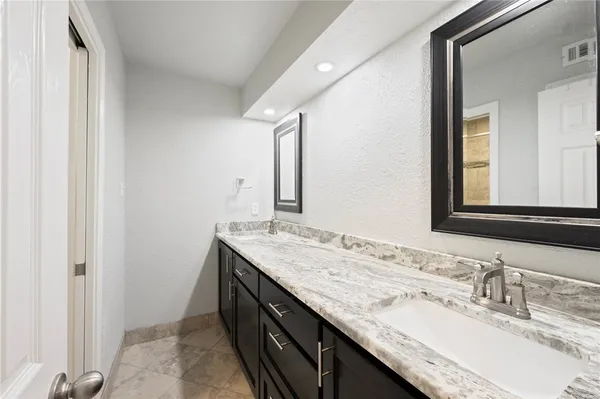 a bathroom with a granite countertop sink and a mirror