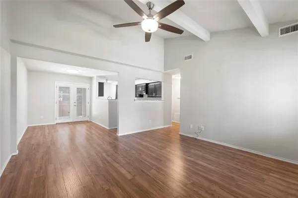 a view of a kitchen with a sink stove cabinets and empty room