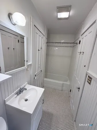 a bathroom with a sink a toilet a mirror and shower