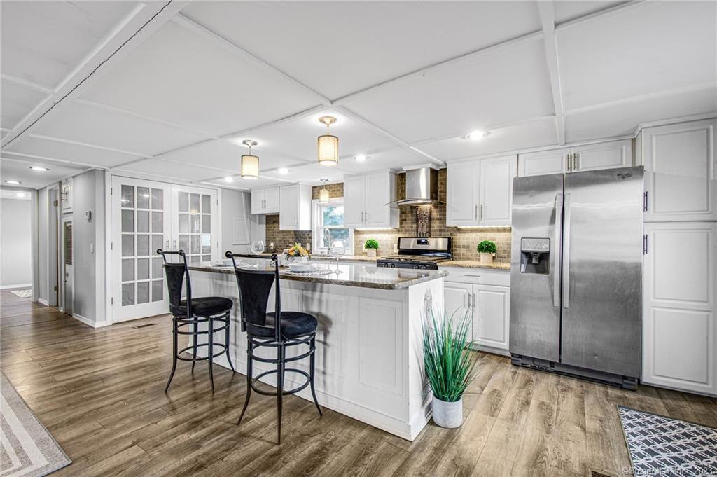 25 Skylark Road Colchester, CT 06415 - Photo 1 of 1 a kitchen with stainless steel appliances granite countertop a refrigerator a stove a sink dishwasher and a dining table with wooden floor
