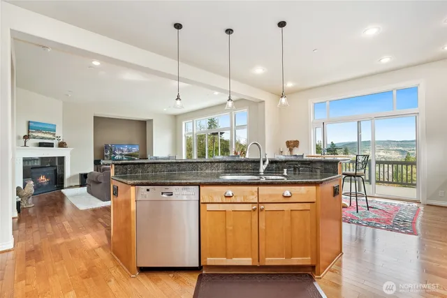 a kitchen with stainless steel appliances granite countertop a stove a sink a oven a dining table and chairs