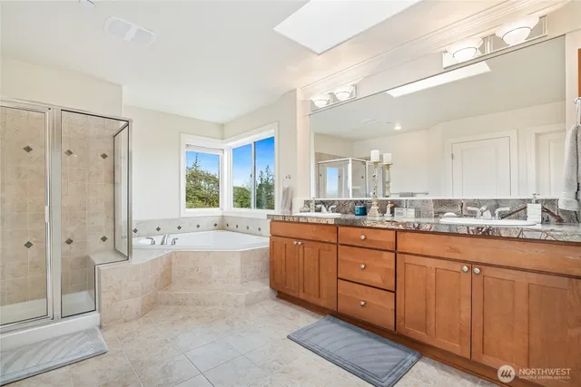 a large bathroom with a granite countertop tub sink shower and mirror