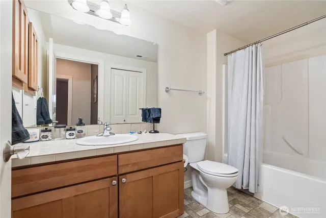 a bathroom with a toilet a sink and a large mirror