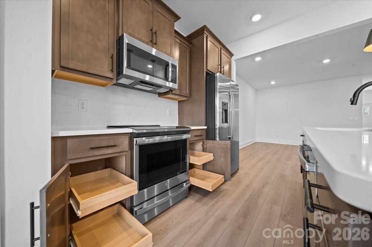 47 Moon Hvn Way Arden, NC 28704 - Photo 5 of 30 a kitchen with a stove a microwave a dining table and chairs with wooden floor