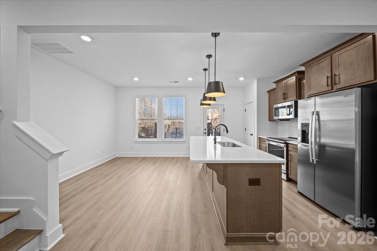 47 Moon Hvn Way Arden, NC 28704 - Photo 7 of 30 a kitchen with stainless steel appliances granite countertop a refrigerator a sink dishwasher a oven and a dining table with wooden floor