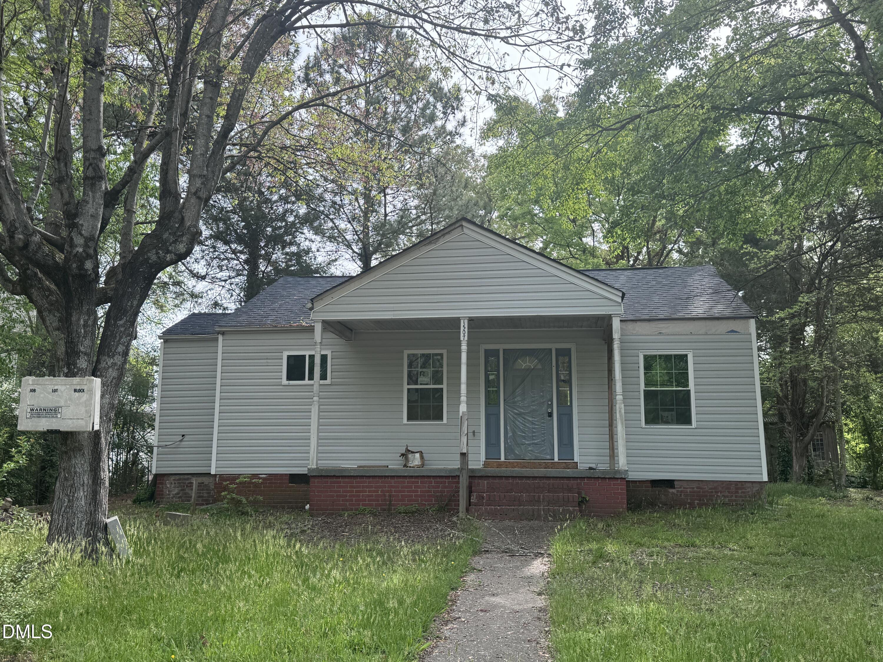 a front view of a house with a garden and yard