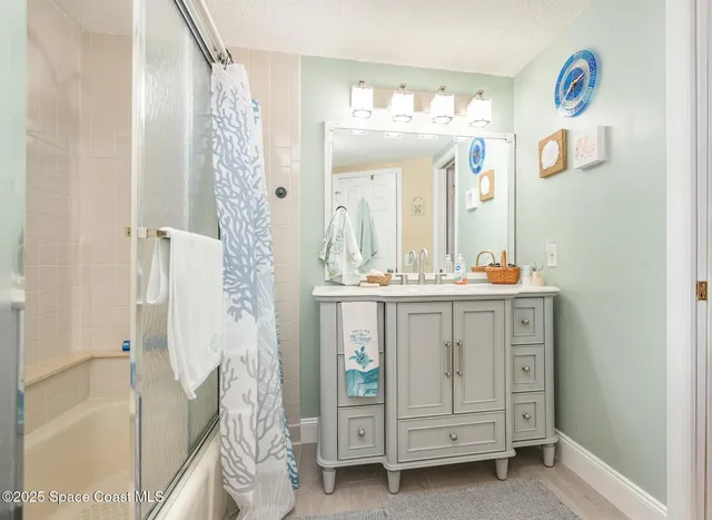 a bathroom with a granite countertop sink mirror and shower