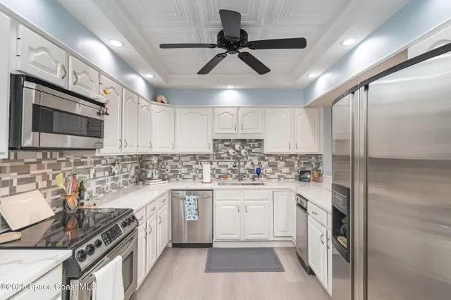 a kitchen with stainless steel appliances granite countertop a sink and a refrigerator