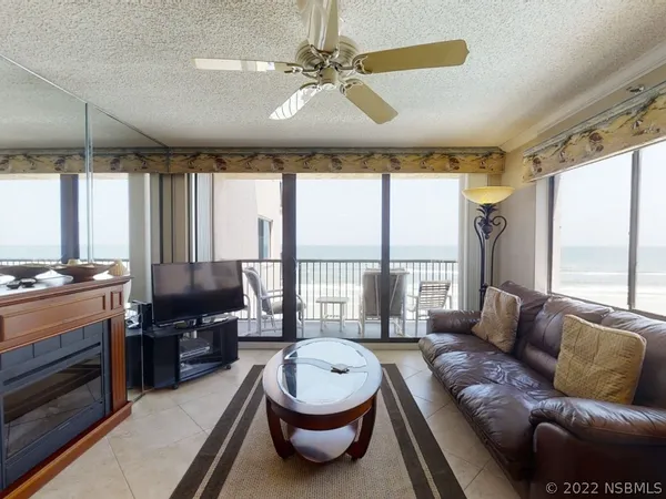 a living room with furniture a ceiling fan and a rug