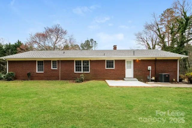 a front view of a house with a yard and trees