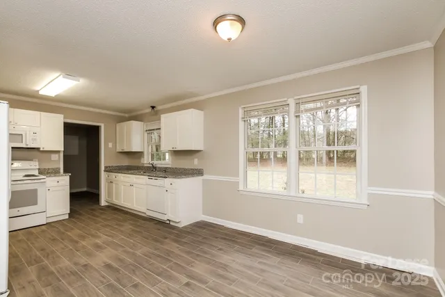 a kitchen with a refrigerator and wooden floor