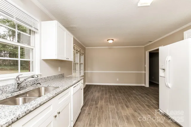 a kitchen with granite countertop a sink and a stove top oven