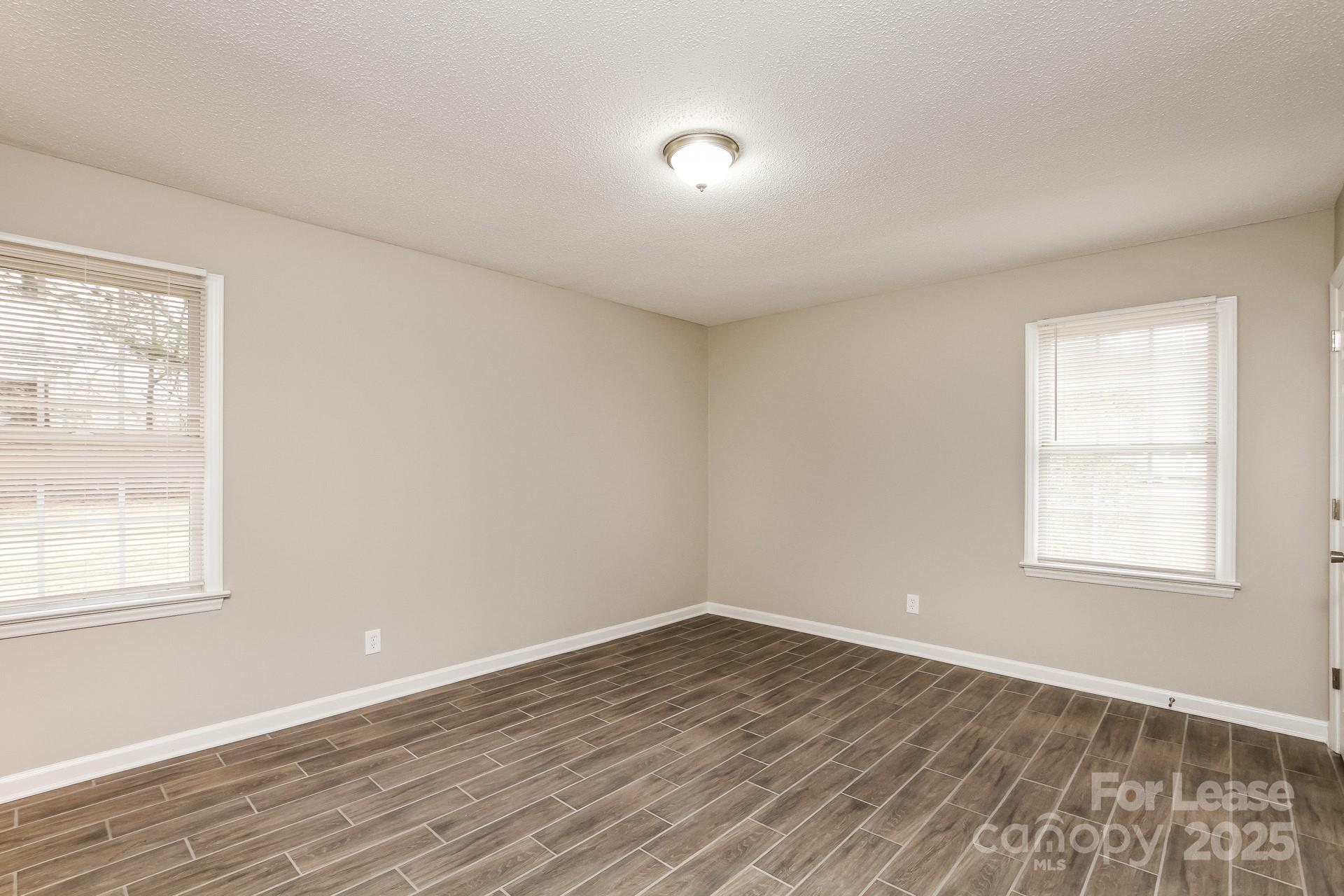 144 Buffaloway Road Statesville, NC 28677 - Photo 9 of 16 an empty room with wooden floor and windows