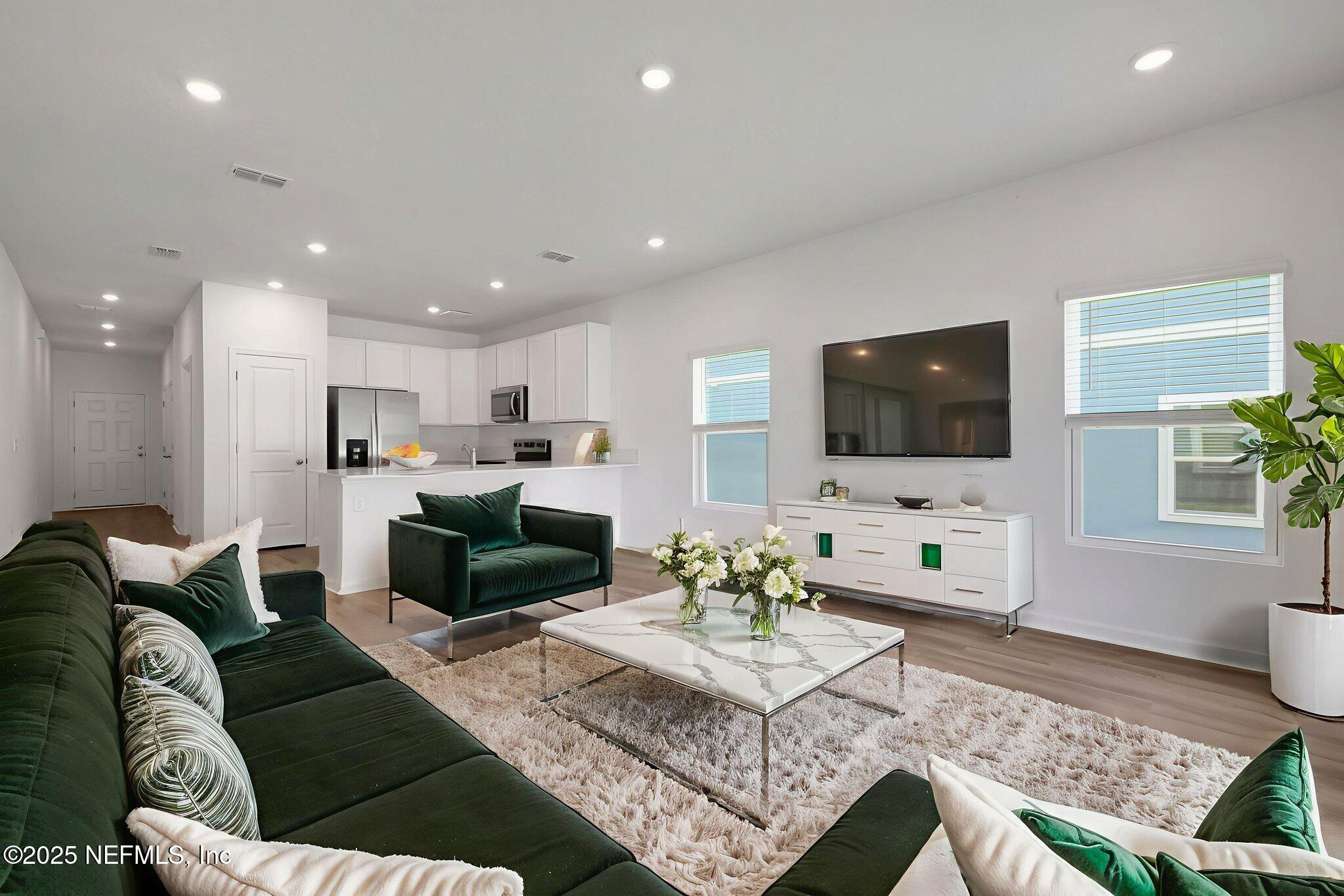 720 Sailor Grove Lane Jacksonville, FL 32221 - Photo 15 of 32 a living room with furniture a flat screen tv and kitchen view