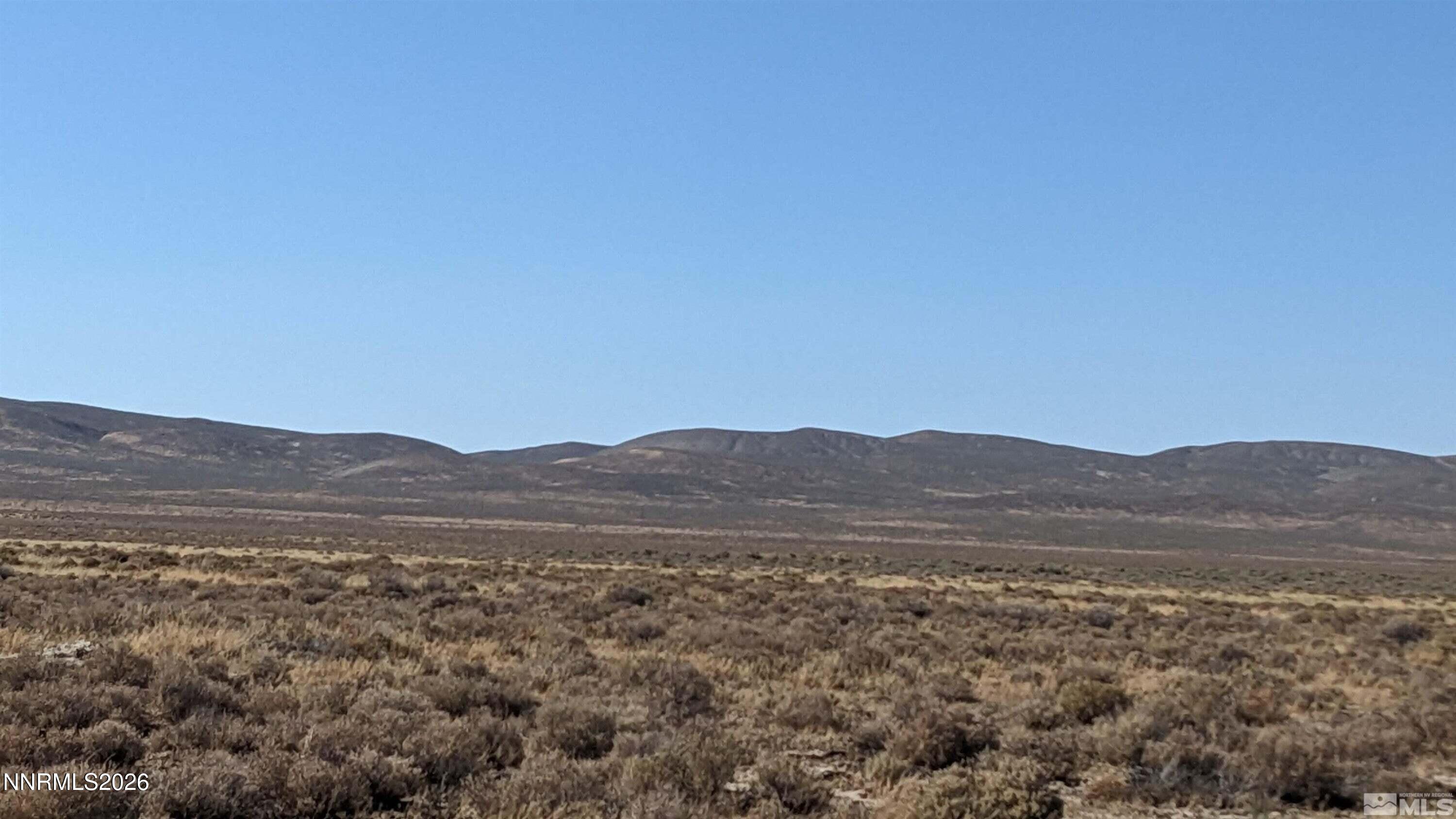 a view of mountain and grassy field