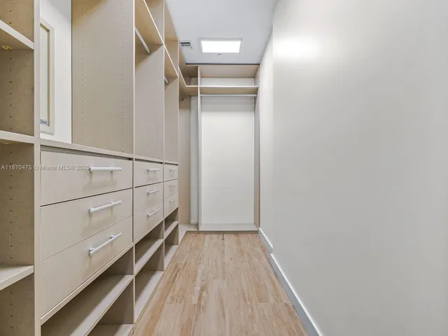 a view of walk in closet with wooden floor