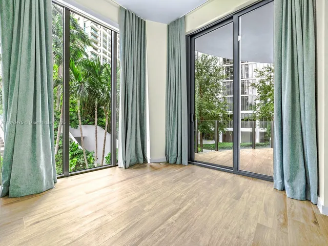 a view of a room with wooden floor and windows