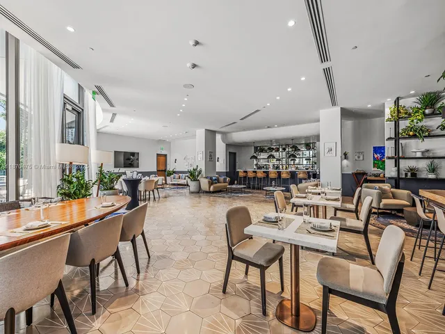 a view of a patio with table and chairs potted plants with floor to ceiling window and garden