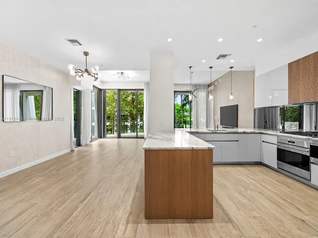 a large kitchen with kitchen island a large counter space a sink stainless steel appliances and cabinets