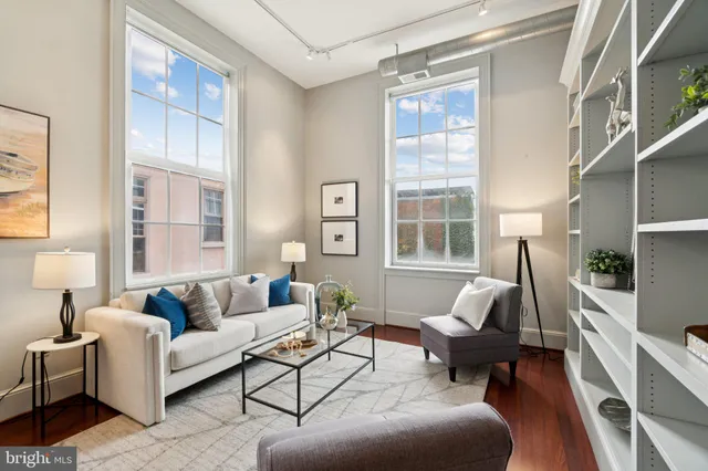 a living room with furniture wooden floor and a large window