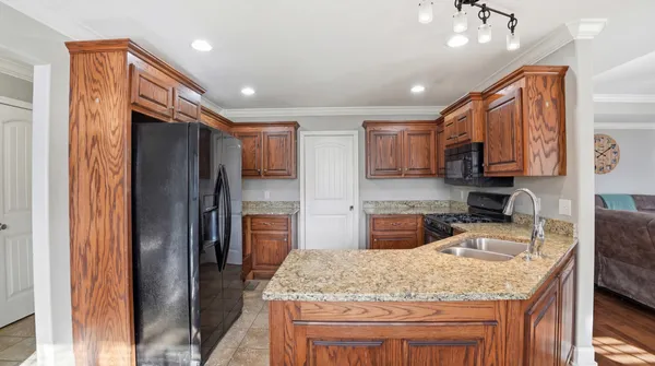 a kitchen with stainless steel appliances granite countertop a refrigerator sink and stove