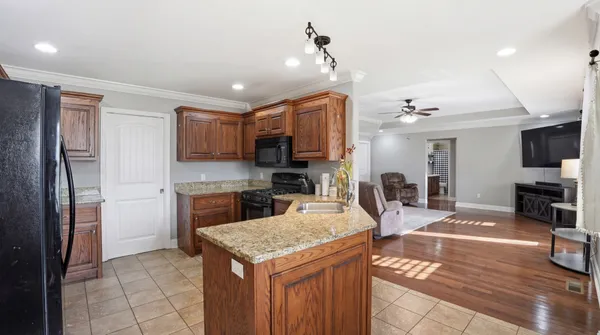 a kitchen with stainless steel appliances granite countertop a refrigerator a sink and a stove