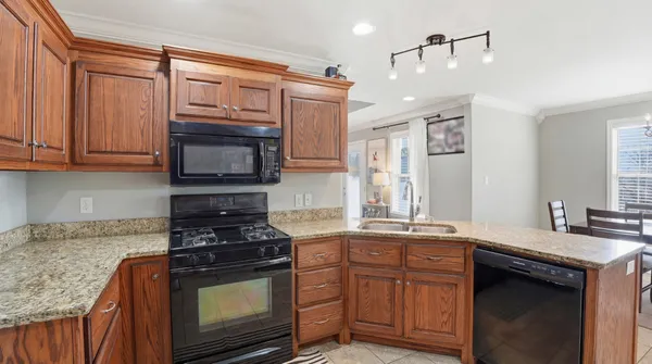 a kitchen with stainless steel appliances granite countertop a stove a sink and a microwave