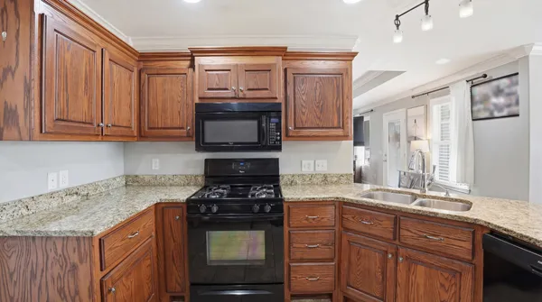 a kitchen with stainless steel appliances granite countertop a stove a sink and a microwave