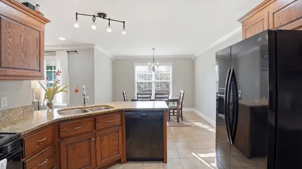 a kitchen with granite countertop a refrigerator and a sink