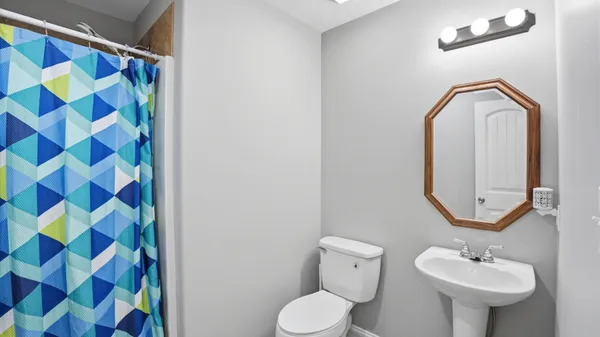a bathroom with a sink and mirror with toilet