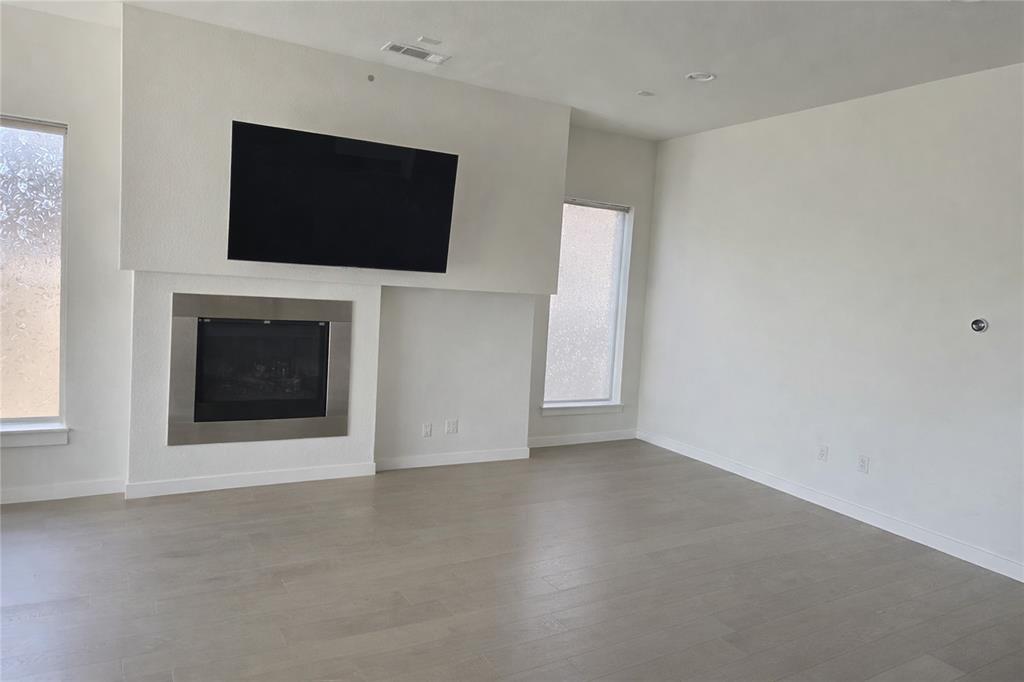 5100 Naphill Road McKinney, TX 75070 - Photo 6 of 22 a view of an empty room with a flat screen tv and a fireplace