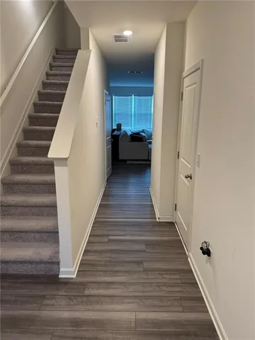a view of a hallway with wooden floor and entryway