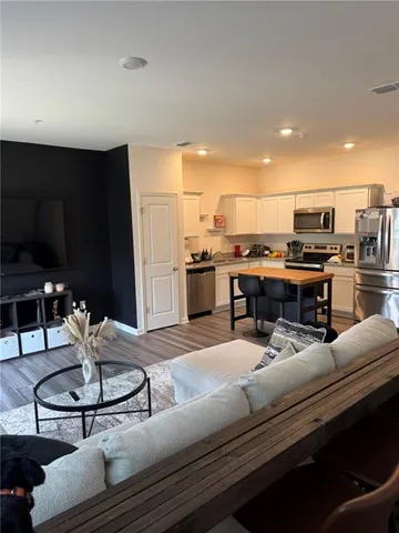 a living room with stainless steel appliances kitchen island granite countertop furniture and a kitchen view