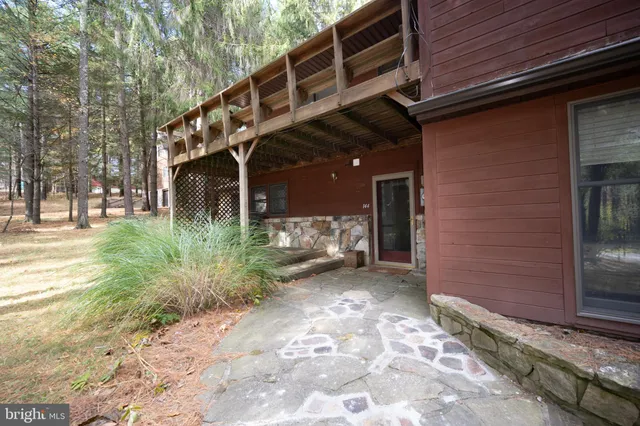 an aerial view of residential house with outdoor space and trees all around