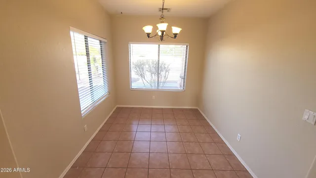 an empty room with windows and chandelier