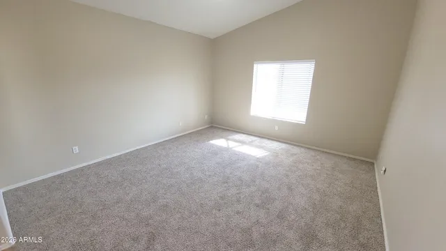 a view of an empty room and a kitchen