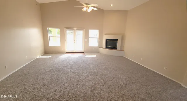 an empty room with windows and fireplace