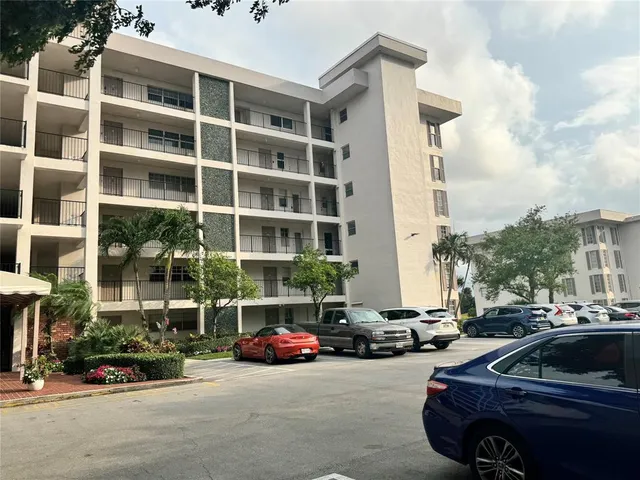a view of a cars park in front of a building