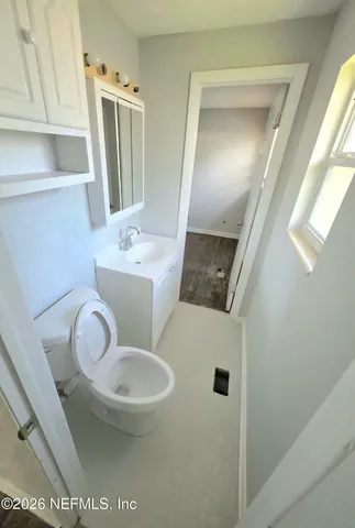 a bathroom with a sink a toilet and mirror