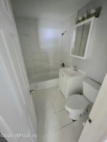 a white toilet sitting next to a bath tub