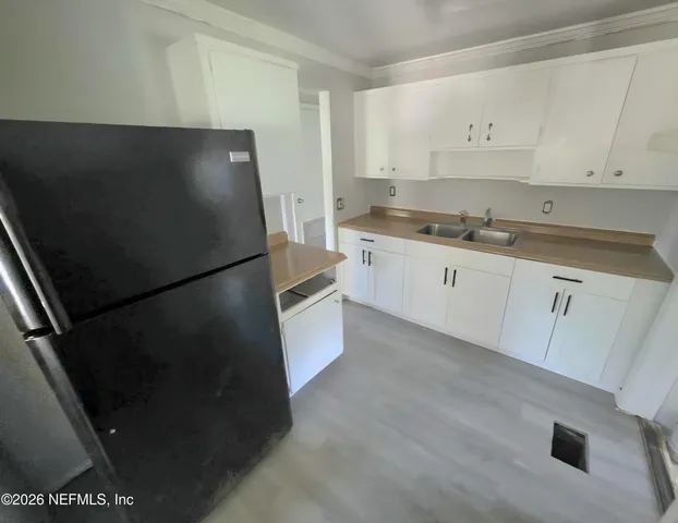 a kitchen with stainless steel appliances a refrigerator sink and white cabinets