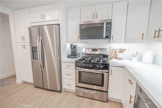 a kitchen with stainless steel appliances a stove a microwave and a refrigerator