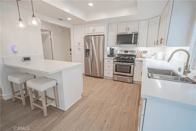 a kitchen with granite countertop a stove a sink and a refrigerator