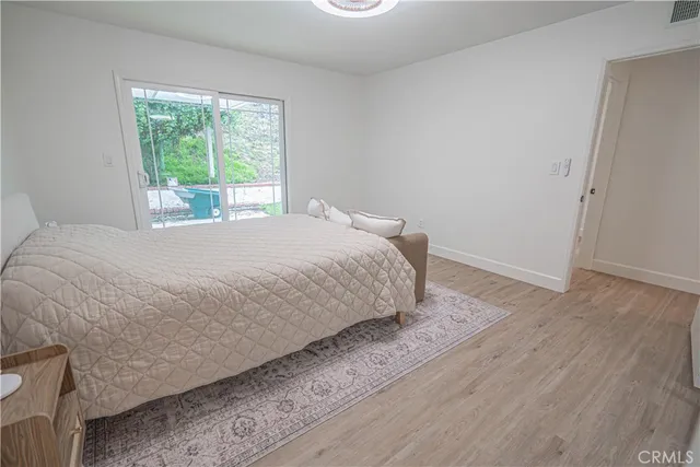 a living room with a bed furniture and wooden floor